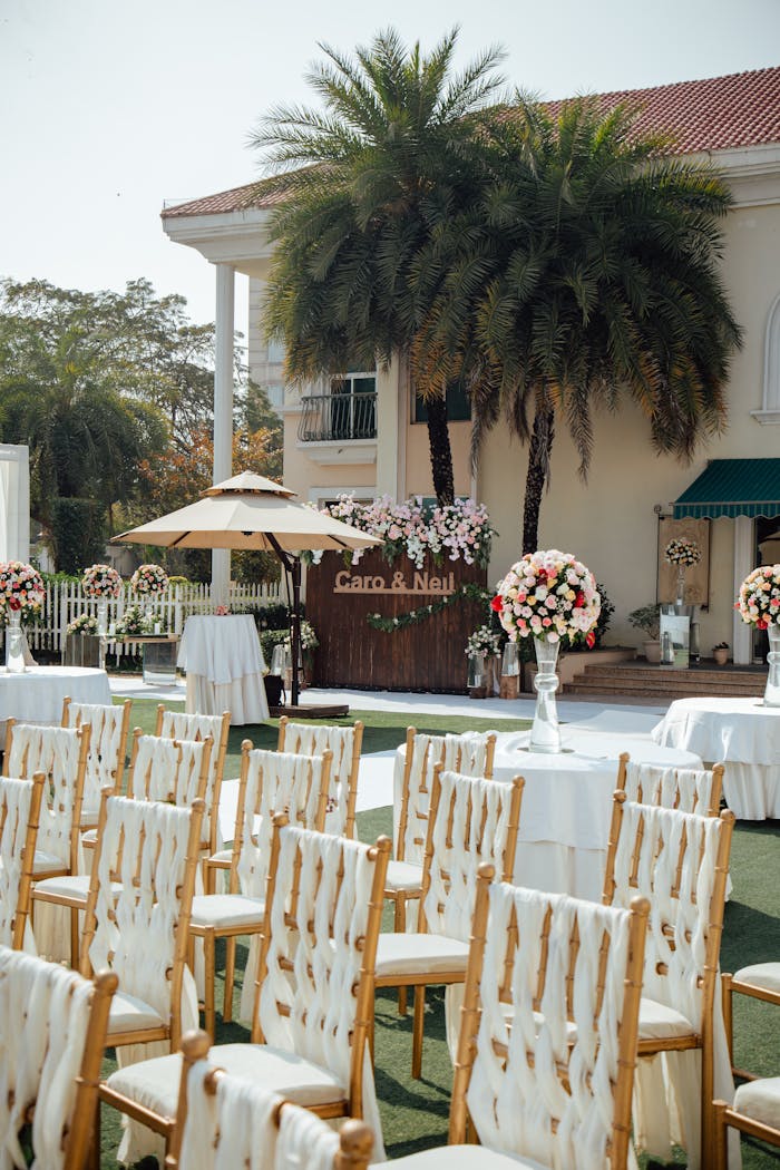 portfolio-02 An elegant outdoor wedding setup with chairs, flowers, and decorations.