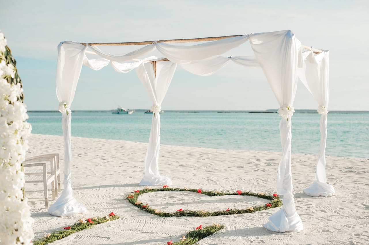 stats-img Beautiful beachfront wedding arch with floral decorations on a sunny day in Maldives.